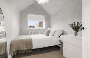 a white bedroom with a bed and a window at Very Luxury home 5min walk to Hertford Town in Hertford