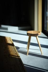 a small wooden stool sitting on top of a floor at JINEN hida takayama in Machikata