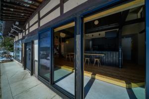 a glass extension of a house with a wooden deck at JINEN hida takayama in Machikata
