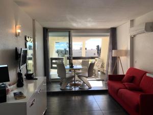 salon z czerwoną kanapą i stołem w obiekcie Résidence Port Nature Colline 4 - Appartement T2 4 pers. - Port Nature Colline 4 MAE-2774 w Cap d'Agde