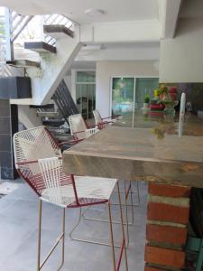 a kitchen with chairs and a large marble counter at Casa Hotel AeroClubR15 in Villavicencio