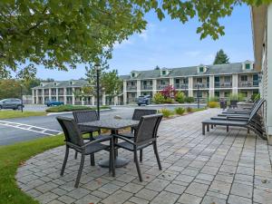 patio ze stołem i krzesłami przed budynkiem w obiekcie Sea Mist Resort Motel w mieście Wells