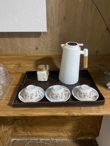 a tray with two plates and a coffee pot on it at Sala e quarto próx ao Maracanã e Engenhão in Rio de Janeiro