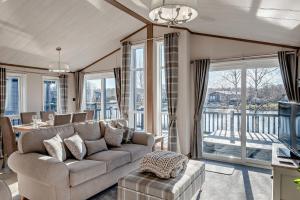 ein Wohnzimmer mit Sofa und Tisch in der Unterkunft Kingfisher Lodge - Lakeside Lodge With Hot Tub in Woodhall Spa