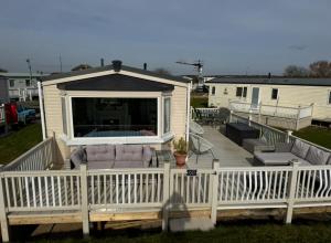 a deck with a couch and chairs on a house at Fraunie's Beach House Anderby Creek - Dog friendly in Anderby