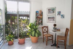 a balcony with plants and a table and chairs at Nostos in Mousata