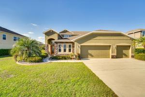 una casa grande con garaje en un patio en 5 Mi to Dtwn Clermont Family Home with Water Views!, en Clermont