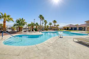 a swimming pool at a resort with palm trees at Spacious Luxe Home with Lake Access in Fort Mohave! in Fort Mohave
