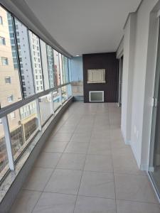 an empty corridor in a building with large windows at Apartamento moderno e funcional bem localizado in Balneário Camboriú