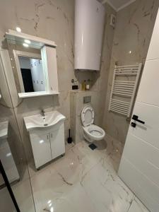 a white bathroom with a sink and a toilet at Apartman Nia in Priboj +12 photos