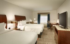 a hotel room with two beds and a flat screen tv at Hilton Garden Inn Salt Lake City/Sandy in Sandy +24 photos