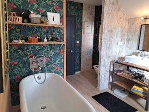 a bathroom with a bath tub and a sink at Chez Laetitia in Gérardmer +10 photos