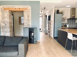 a kitchen and a living room with a couch and a table at Le balcon du boulevard bellevue in Saint-Claude