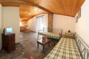 a living room with two beds and a television at Nostos in Mousata
