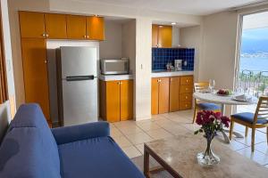 a living room with a blue couch and a kitchen at Partial View, WiFi, Pool & Beach Access! in Puerto Vallarta