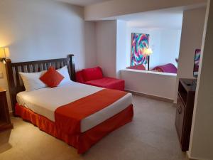 a hotel room with a bed and a red chair at Spacious, standard with beach access & wifi! in Puerto Vallarta +28 photos