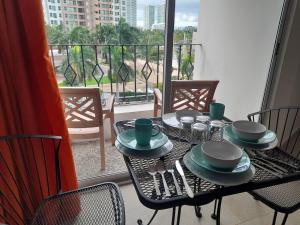 a table with plates and utensils on a balcony at Spacious, standard with beach access & wifi! in Puerto Vallarta