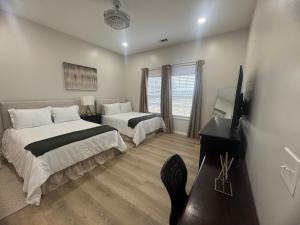 a bedroom with two beds and a television in it at A Charming Villa in Vidalia GA - New Construction in Vidalia