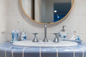 a bathroom sink with a mirror and blue and white dishes at King Bed Harbour View - Captain's Retreat in Sydney +17 photos