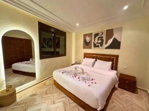 una camera da letto con due letti con fiori rossi sopra di Exclusive Luxury Stay with Pool, Jacuzzi and Service a Marrakech Altre 33 foto