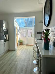 a large kitchen with a large clock on the wall at Charming city home free parking in Portsmouth