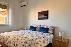 Un dormitorio con una cama con almohadas azules. en Emma's House, en Agrigento