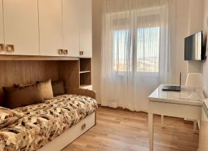 a bedroom with a bed and a desk and a window at Emma's House in Agrigento