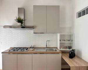 a white kitchen with a sink and a stove at Emma's House in Agrigento