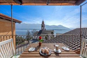 un tavolo su un balcone con vista sull'acqua di Red View Apartment - Happy Rentals a Ronco sopra Ascona
