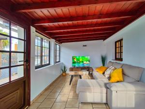 Una sala de estar con un sofá y un televisor. en Casa Las Martina, en La Verada