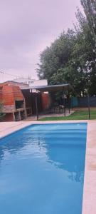 a large blue swimming pool in front of a house at Cabaña DON LITO in Ciudad Lujan de Cuyo
