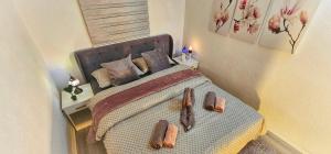 a bedroom with a bed with two slippers on it at Villa White Pearl Buna in Hodbina +49 photos