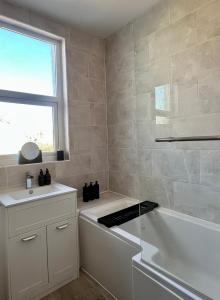 a white bathroom with a tub and a sink at Charming city home free parking in Portsmouth