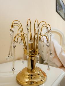 un vase en or assis au-dessus d'une table dans l'établissement Casa la Pieve, à Berat