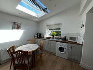 a kitchen with a table and a sink and a microwave at 3br-Sea View-Fireplace-Garden-Free Parking in Falcarragh +31 photos
