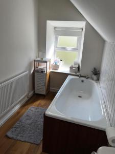 a large bath tub in a bathroom with a window at 3br-Sea View-Fireplace-Garden-Free Parking in Falcarragh