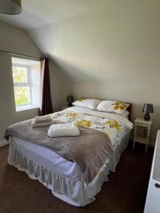 a bedroom with a large bed with towels on it at 3br-Sea View-Fireplace-Garden-Free Parking in Falcarragh
