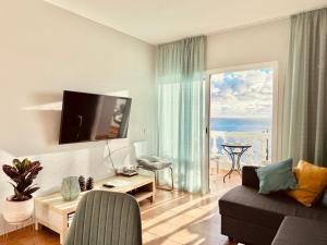 a living room with a couch and a view of the ocean at Sunset apartment in Puerto de Santiago