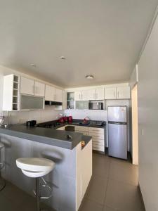 a kitchen with white cabinets and a white refrigerator at Dpto en Paracas con vista al Mar in Paracas +7 photos