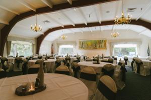 um salão de banquetes com mesas, cadeiras e lustres em Town & Country Inn & Resort em Gorham
