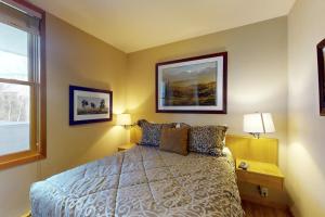 a bedroom with a bed and two lamps and a window at River Bank Lodge 2919 in Keystone