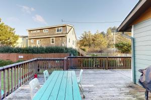 a wooden deck with a green table and chairs at Darrs Beach Cottage in Neskowin