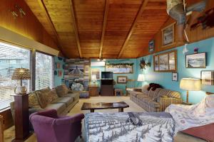 a living room filled with furniture and a wooden ceiling at Darrs Beach Cottage in Neskowin