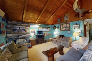 a living room with blue walls and wooden ceilings at Darrs Beach Cottage in Neskowin +24 photos
