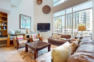 una sala de estar con un sofá y una mesa en Sapphire Bungalow #106, en South Padre Island