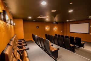 una sala de conferencias con sillas negras y una pantalla en Sapphire Bungalow #106, en South Padre Island 30 fotos más