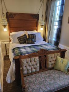 a bedroom with a large bed with a wooden headboard at The Tamworth Hotel, Tamworth ,Ontario, Canada in Tamworth