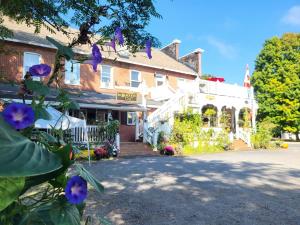 a building with purple flowers in front of it at The Tamworth Hotel, Tamworth ,Ontario, Canada in Tamworth