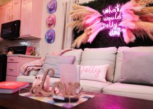 a living room with a white couch with pink feathers at Dolly's Place 6260 in Dover