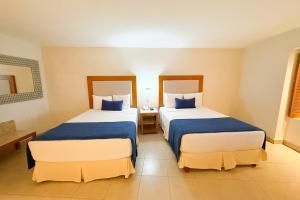 Una habitación de hotel con dos camas con sábanas azules. en Oceanfront development, ideal for relaxation!, en Puerto Vallarta 18 fotos más